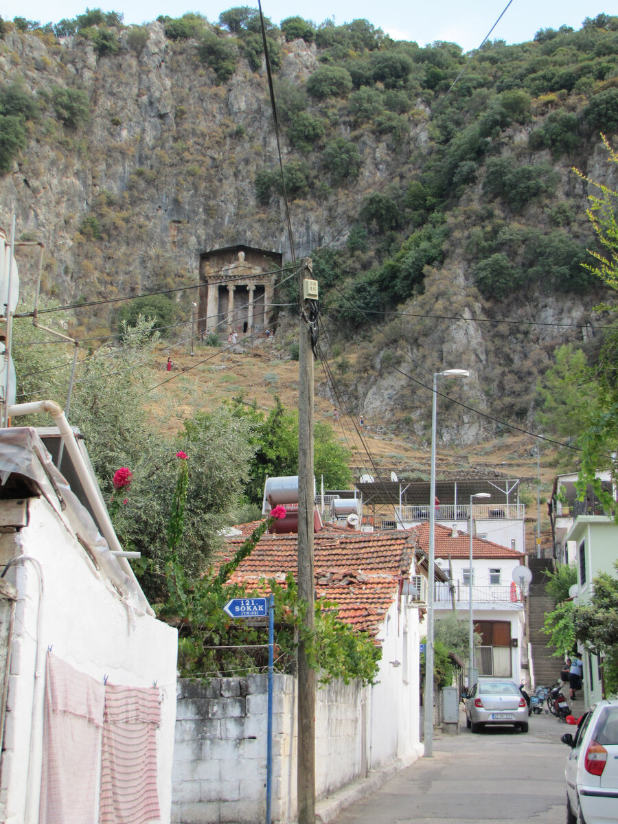 Скала с гробницами вздымается прямо у черты города