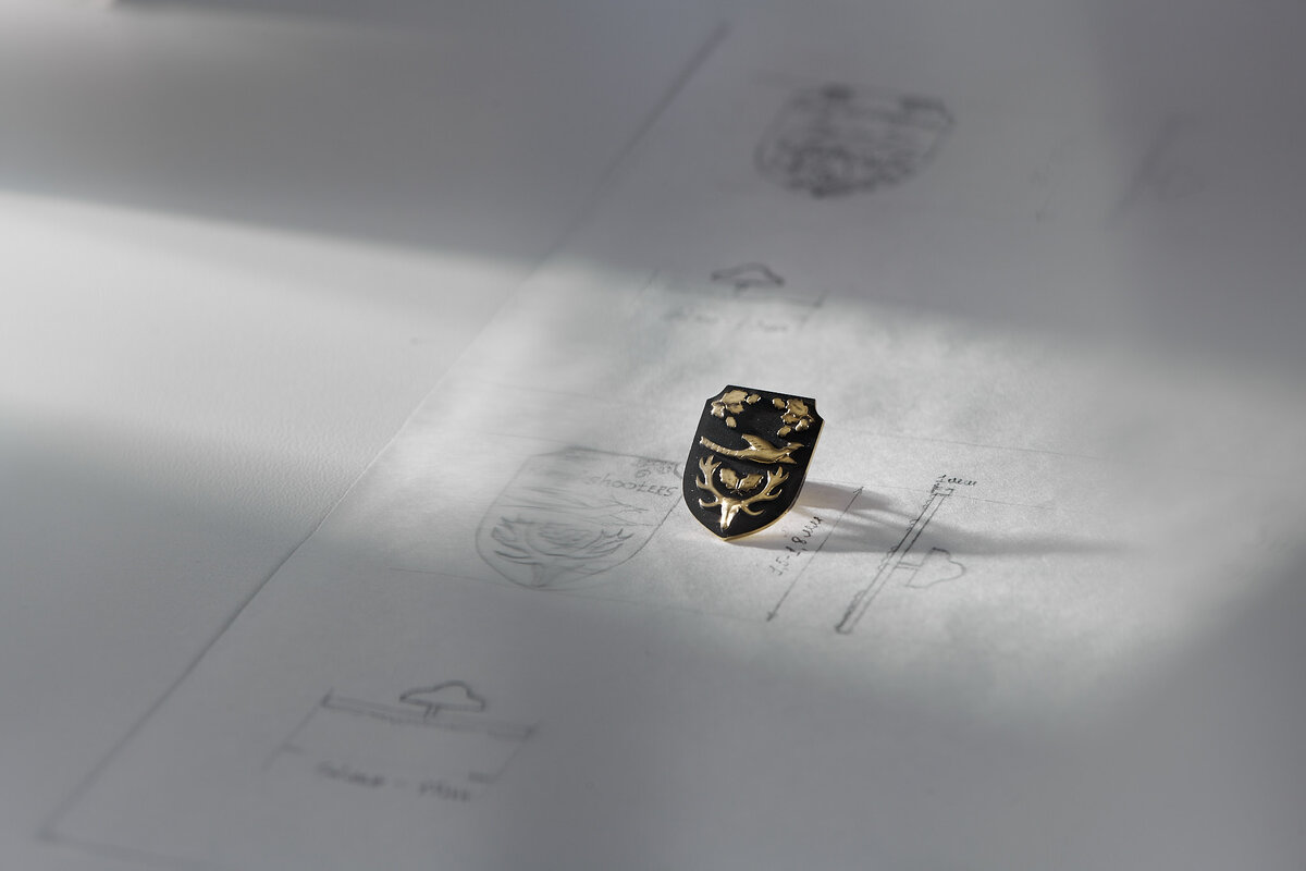 Знак полностью отражает фирменную эмблему клуба. В технике рельефа выполнены благородный олень, летящий фазан, ветви дуба и желуди. Они выступают как символы долголетия, благородства, выносливости, мужской силы и плодородия.

Все члены клуба при вступлении получают этот знак, отмечающий принадлежность к клубу.