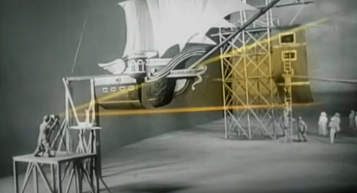 Уменьшенный макет корабля с вырезом под проекцию полномасштабной части корабля с которой взаимодействуют актеры. Кадры из д/ф “Великие комбинаторы”.