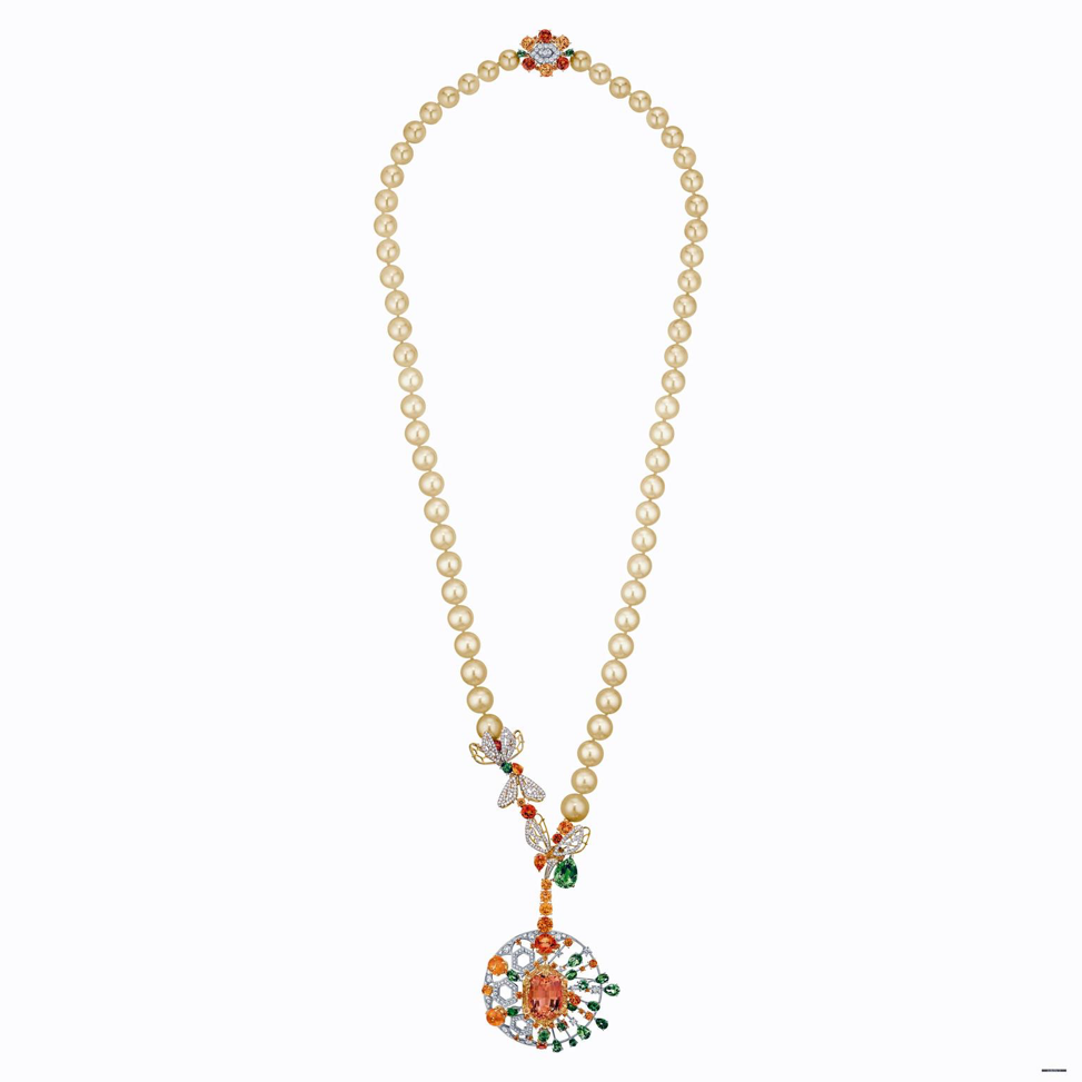 Колье Chaumet, которое можно трансформировать в брошь из желтого и белого золота, украшенное Императорским топазом 23,42 карата, зелеными турмалинами, золотым культивированным жемчугом, гранатами-мандаринами, цаворитами и бриллиантами круглой огранки.