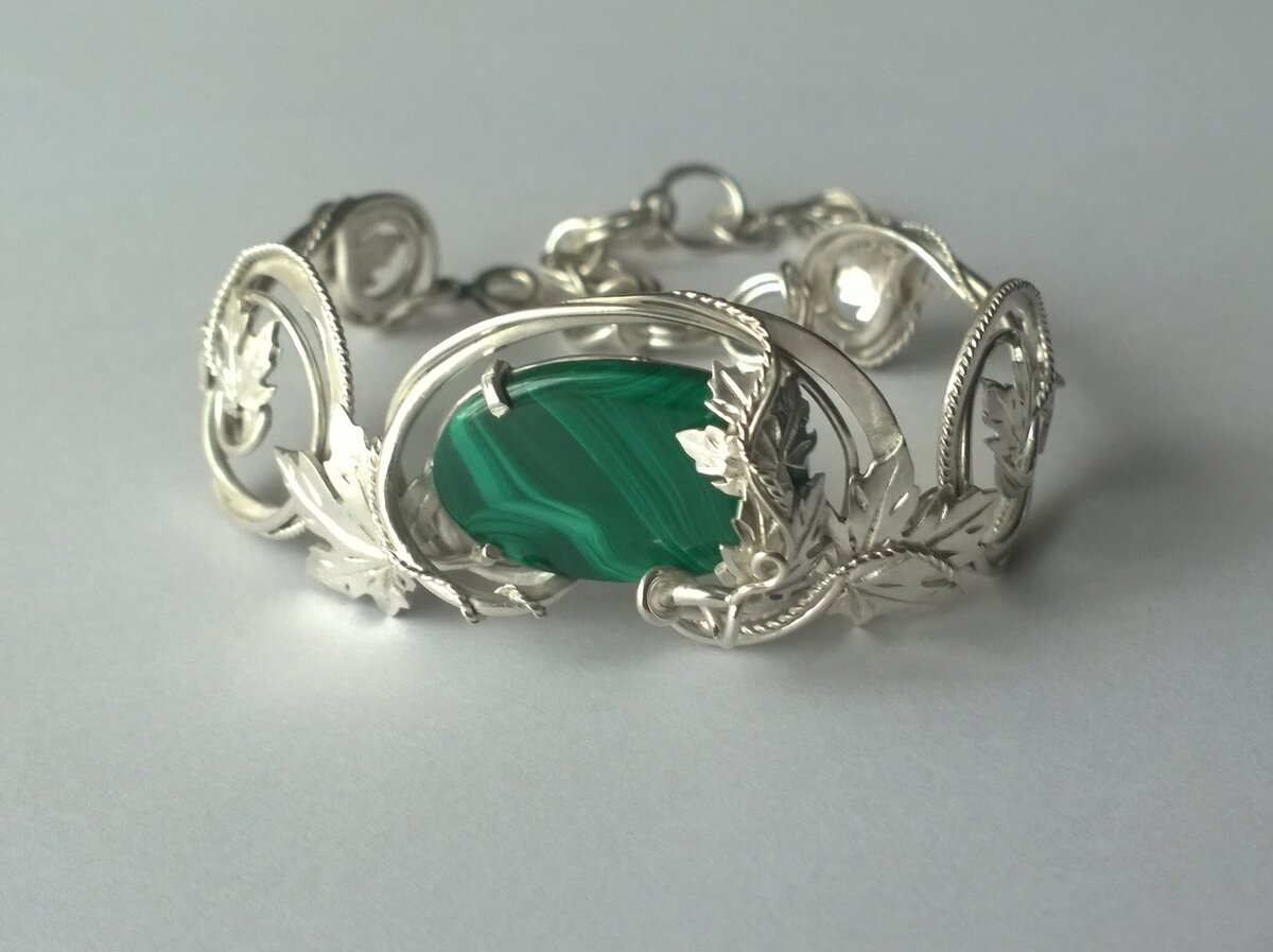 Браслет с натуральным малахитом. Хитросплетения проволоки, узоры и листья -перетекают от изгибов к капелькам-зернинкам.