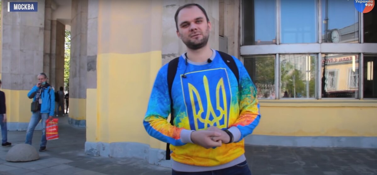 Стоит довольный, улыбается.