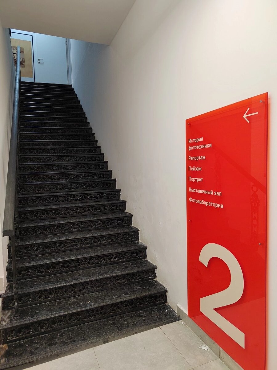 Современные указатели и старинная лестница в музее