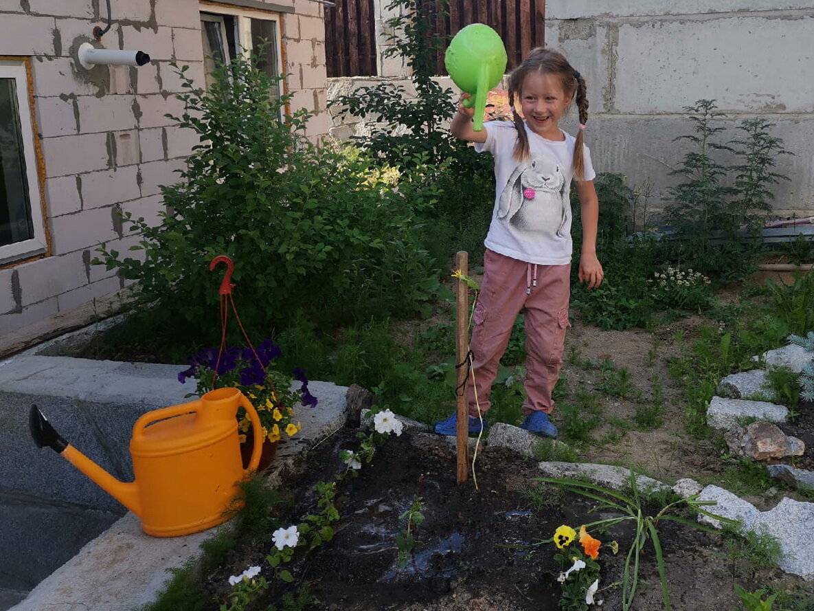 Приходится бегать по грядкам и клумбам с леечками, ведь систему полива демонтировали. А Саша только рада