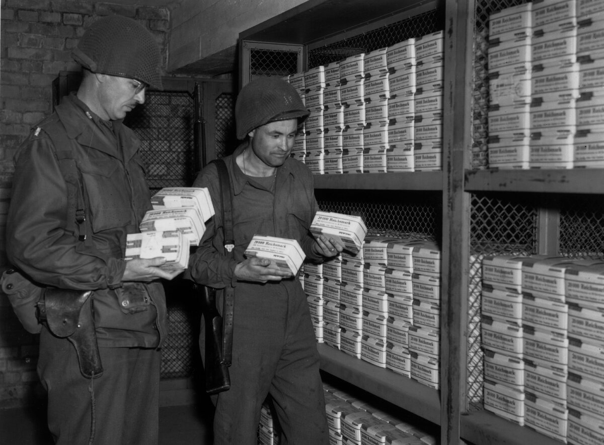 Американские офицеры Б. Томпсон и В. Хэппи с пачками денег в хранилище банка Магдебурга, 27 апреля 1945 года / Фотограф Фред Ремедж