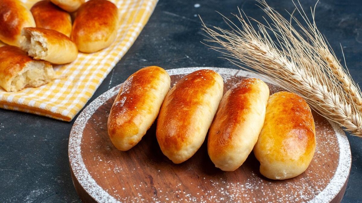    top view potato piroshki on kitchen towel and wood board wheat on table copy space