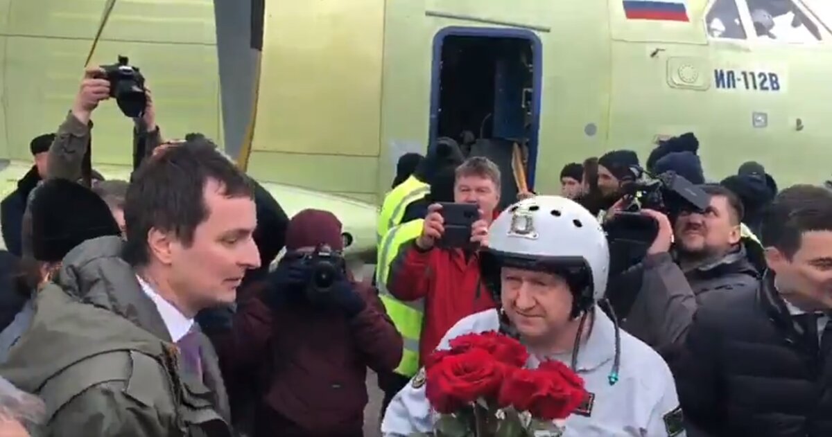 Глава Ила Алексей Рогозин встречает лётчика-испытателя Николая Куимова после первого полёта на фоне зафлюгированных винтов отказавшего двигателя Ил-112В