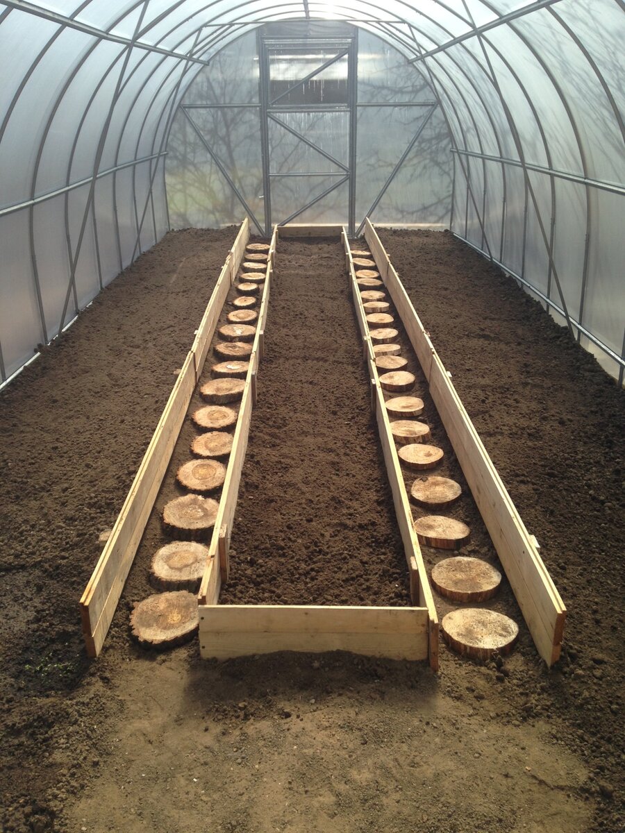 Доски в качестве ограждений - самый понятный и распространенный в теплицах вариант