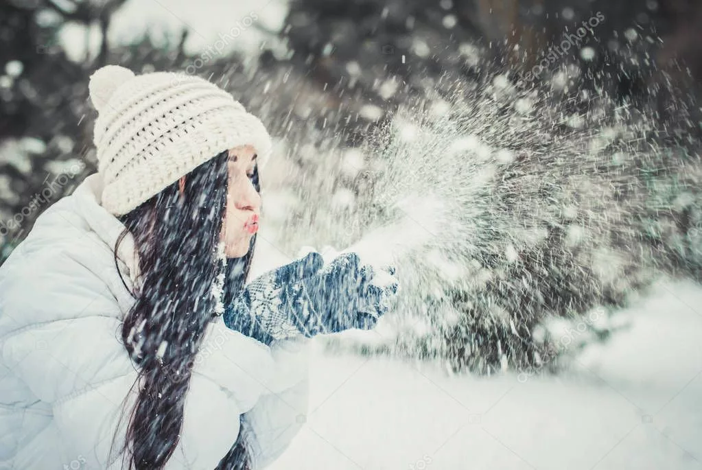 The snow be is blowing. Зима девушка дует. Девочка дует на снег. Брюнетка дует на снег. Девушка дует на снег фото.