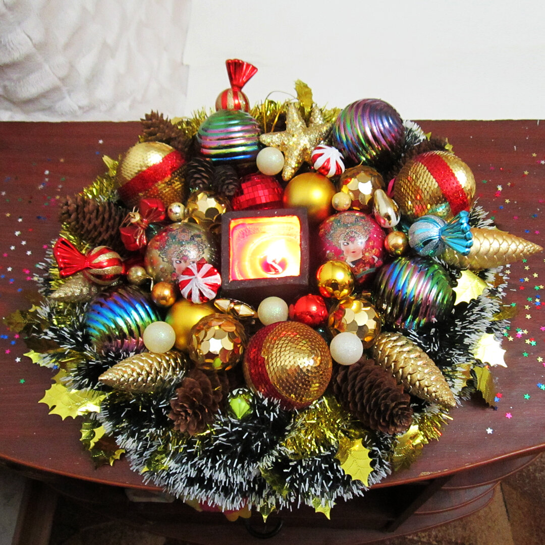 вместо ёлки можно сделать венок из мишуры и шариков, поставив в середину безопасную свечу или лампу. 