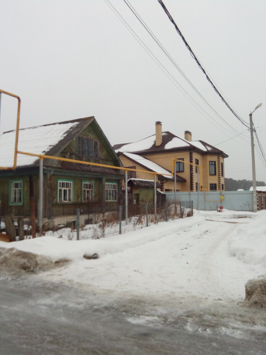 Старые дома поселка чередуются с новыми коттеджами