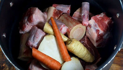 В большую кастрюлю положите все мясо (говяжьи кости, можно использовать хвосты быка и филейную часть обязательно) и овощи для бульона: репчатый лук, морковь, пастернак и стебель сельдерея (вам не нужно чистить их, так как они будут выброшены после того, как сварятся ).