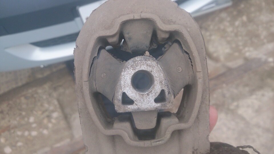 На фото видно что подушка или опора двигателя порвана и требует ремонта.