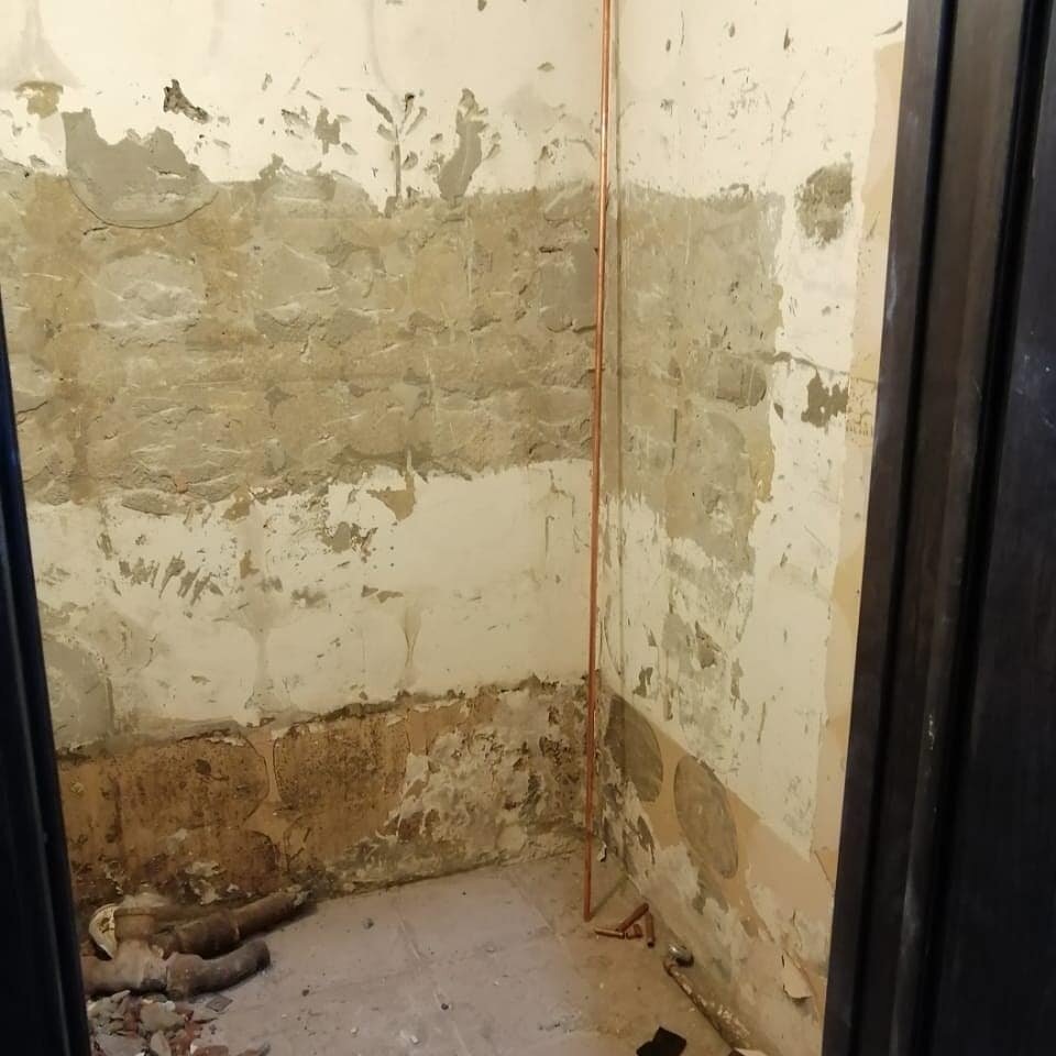 Первым делом сняли всю прежнюю плитку, заменили канализационные и водопроводные трубы, обновили гидроизоляцию пола.