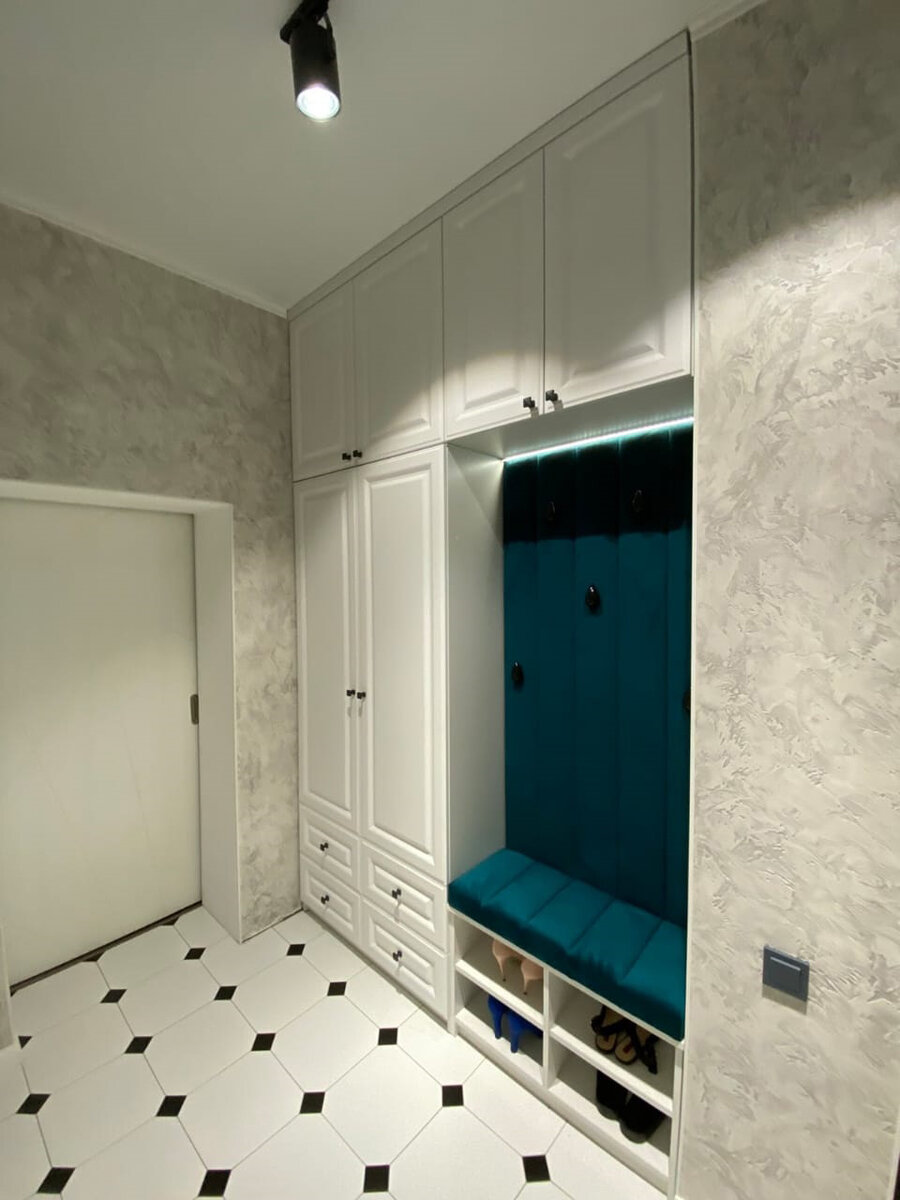 Светлая прихожая с мягкой обивкой цвета морской волны