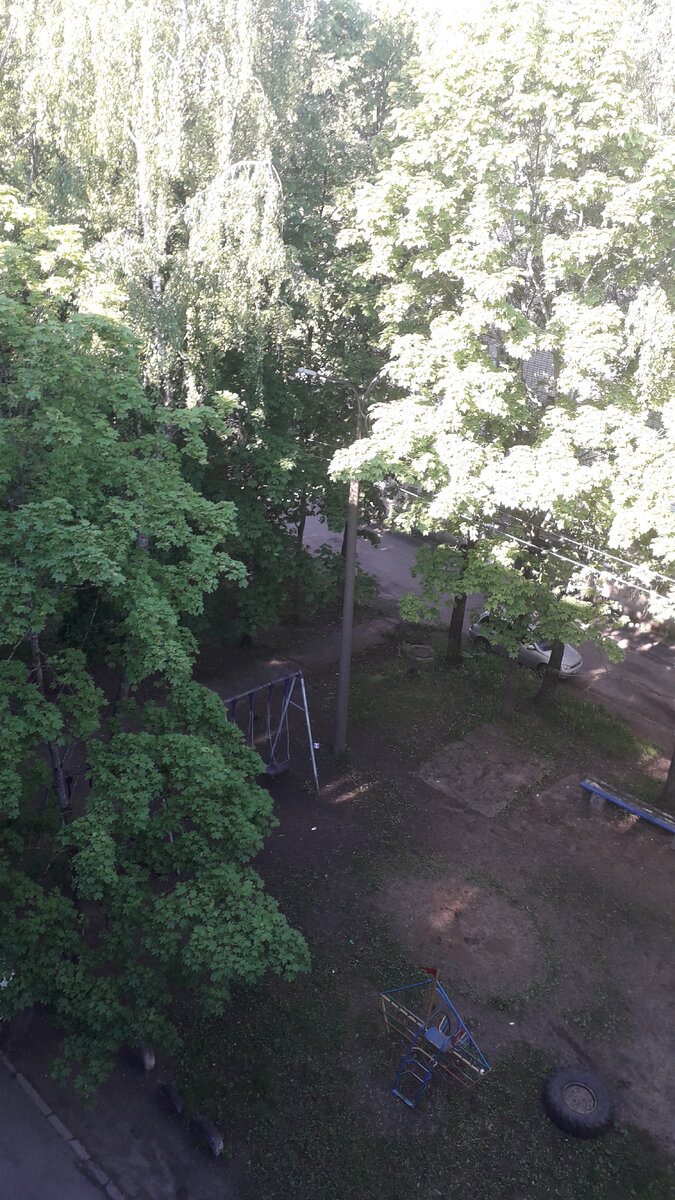 Фото автора. Вид на детскую площадку с балкона. Наши еще совдеповские качели.