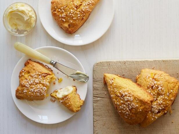 Эти мягкие слоистые булочки отличаются чудесным сливочно-пряным вкусом, который им дарят настоянные на шафране жирные сливки. Ароматизированные сливки добавляются и в тесто, и используются для смазывания булочек перед выпеканием. Сконы получаются чуть сладкими, с сочными вкраплениями изюма и хрустящей сахарной корочкой. Ешьте их тёплыми, смазывайте сливочным маслом и наслаждайтесь. 