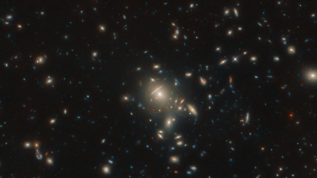 В центре данного изображения находится массивное скопление галактик; вдоль его границ видны красноватые точки; это копии одной и той же галактики под названием PLCK G045.1 + 61.1, которая находится на расстоянии 12 миллиардов световых лет от нас. 