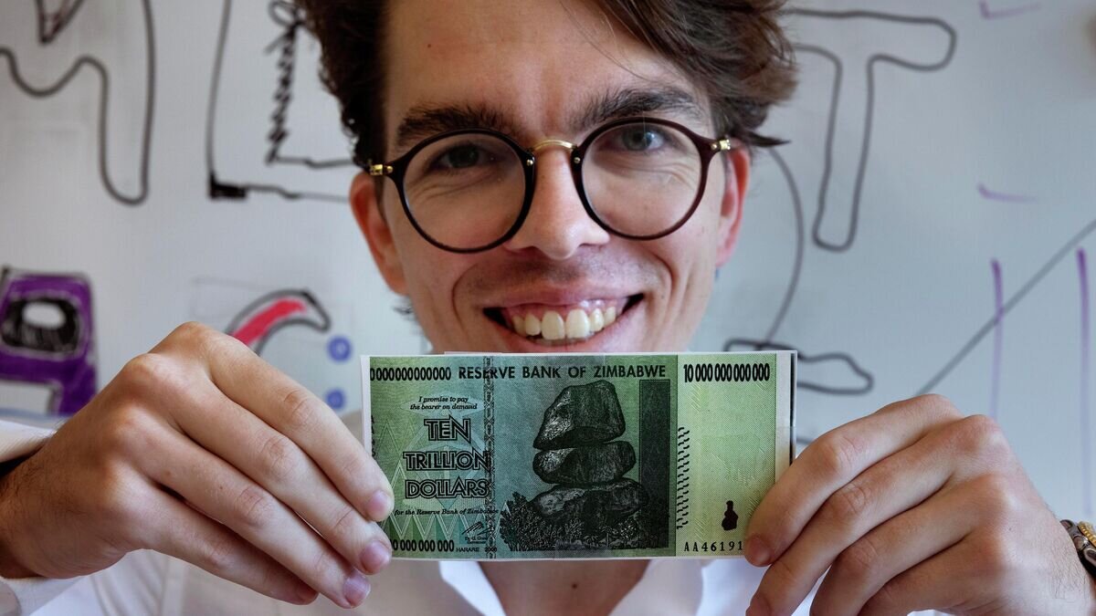    Лауреат Шнобелевской премии Эрик Мартинес, получивший премию за анализ того, что делает юридические документы "излишне трудными для понимания", с зимбабвийской купюрой в 10 триллионов долларов© AP Photo / Michael Dwyer