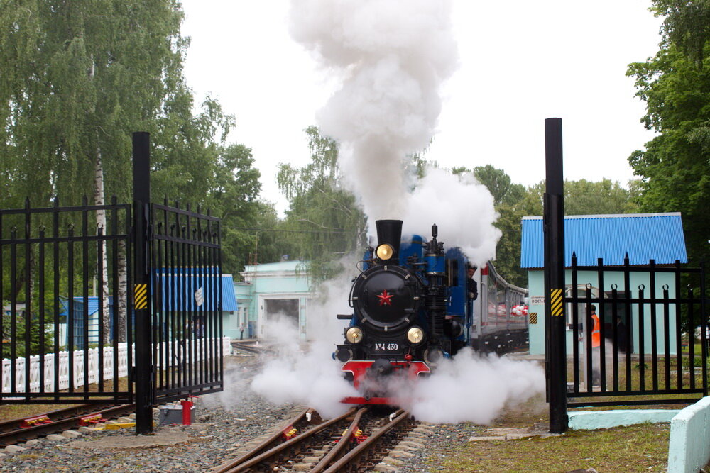 Они всегда приковывали внимание к себе. Вот представьте себе. Идут по улице дети в железнодорожной форме. Раньше их еще и на трамвае в ней бесплатно катали. Из солидарности. Сейчас, правда, такого нет, но в этот день на свою работу они бежали вприпрыжку. На Детской железной дороге, ее еще называют Малой Горьковской, начался сезон летней практики. Это значит, что поезда под управлением детей, но под четким присмотром взрослых начали ходить по расписанию и возить пассажиров. В честь праздника на рейс поставили старенький паровоз. В прошлом году его подшаманили специалисты из Санкт-Петербурга, он помолодел и стал звать пассажиров на борт своим басовитым гудком. Полюбуемся на состав и прокатимся? 