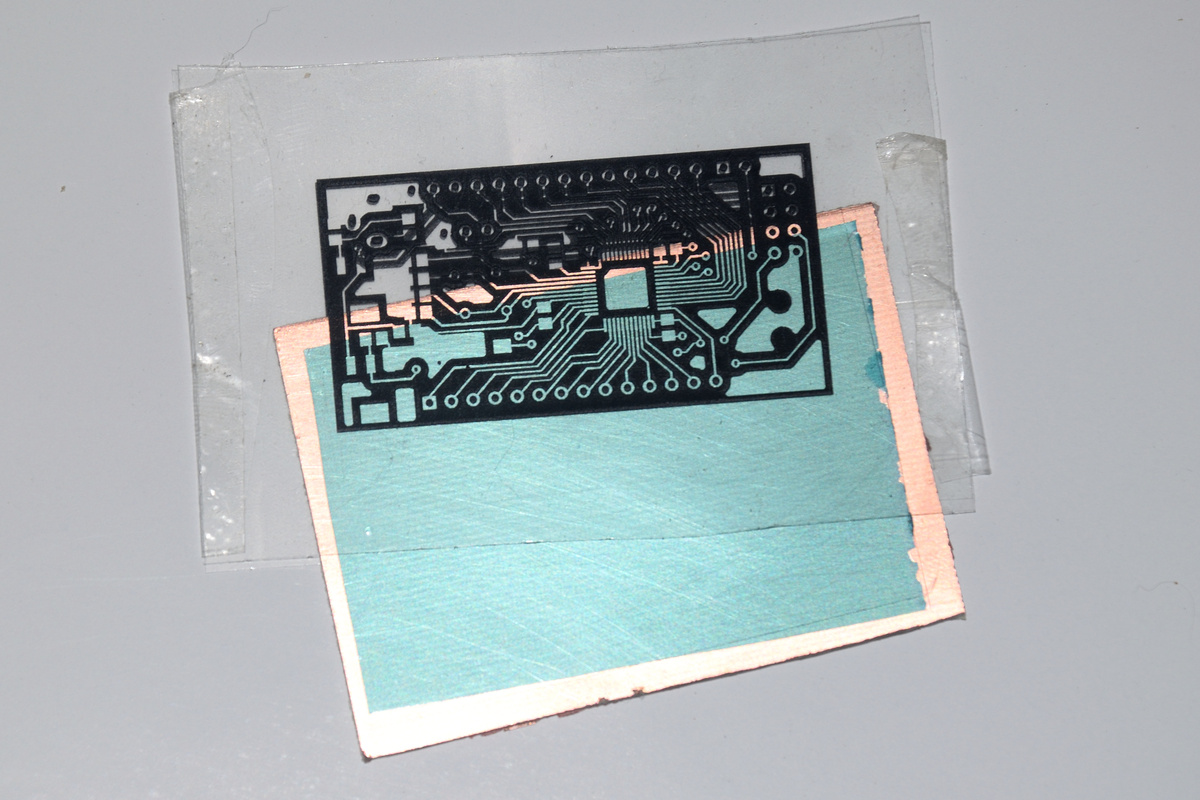 Фото 2. Вставляем заготовку в полученный шаблон. Видно, что справа и слева листы шаблона скреплены скотчем. Показана правильная ориентация шаблона.