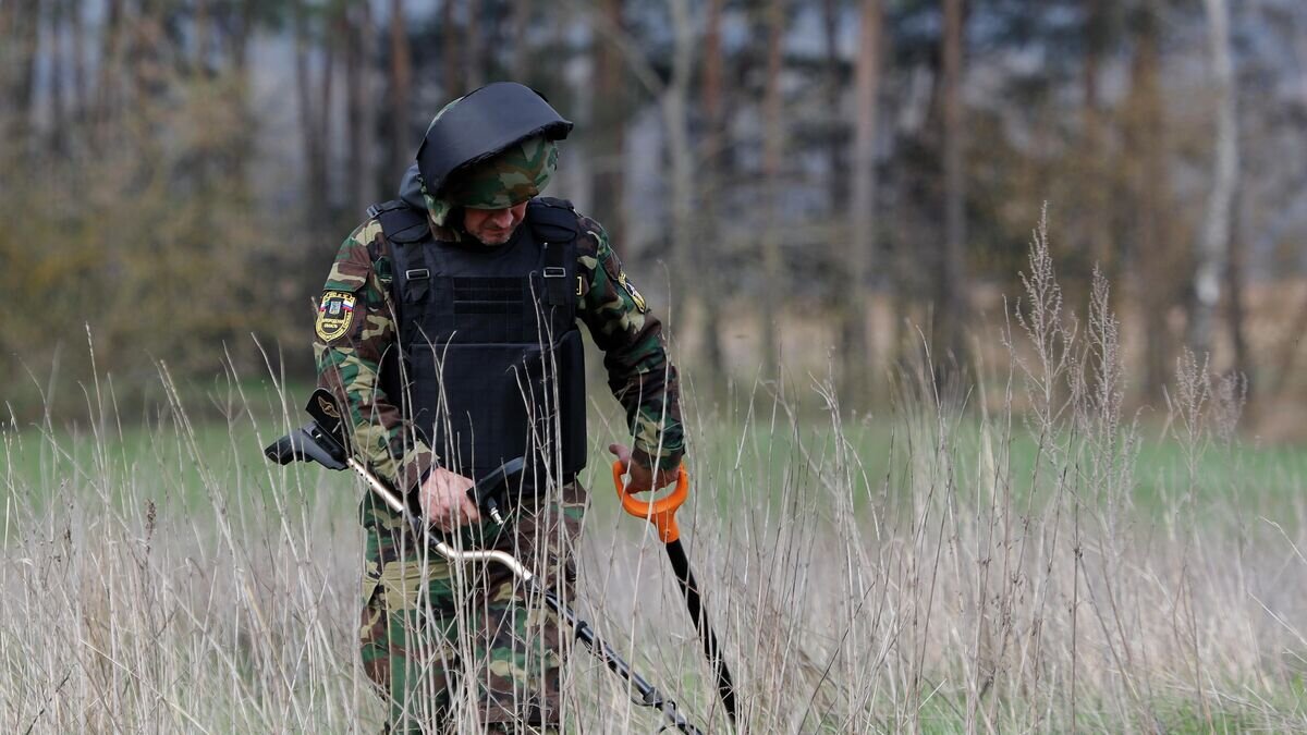    Сотрудник поисково-спасательной службы МЧС РФ занимается поиском фрагментов снаряда ВСУ в селе Головчино в Белгородской области© РИА Новости / Таисия Лисковец