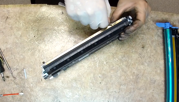 Фото 65. Если тонер перестает просыпаться, крутим шестерню, указанную стрелкой, тем самым прокручиваем поролоновый ролик подачи тонера и помогаем тонеру попадать в бункер