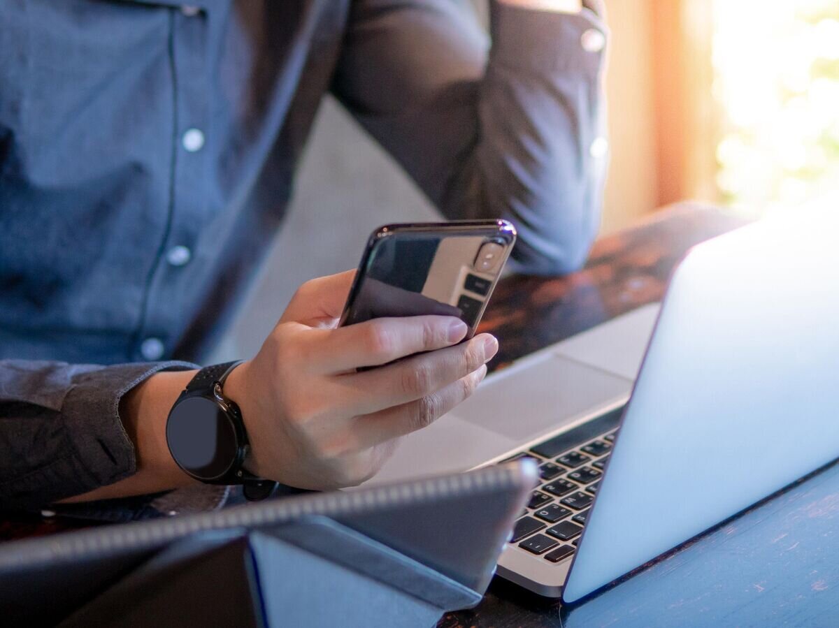    Мужчина использует ноутбук и смартфон для работы© iStock.com / Zephyr18