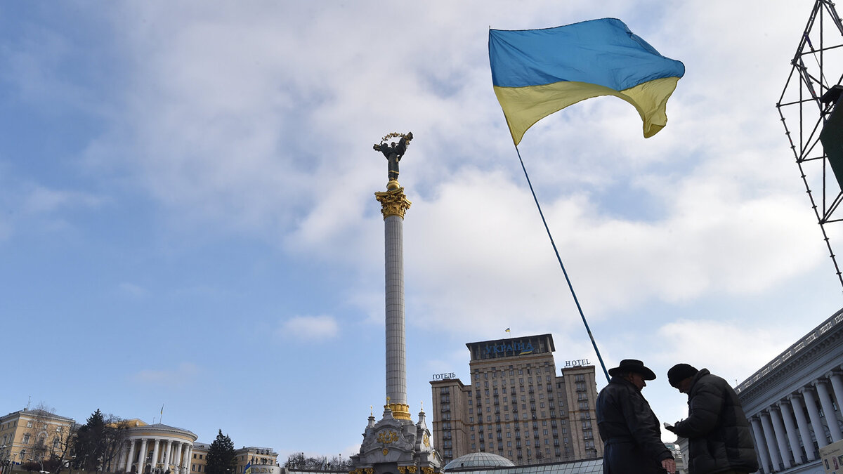    " Активисты с украинским флагом на площади Независимости в Киеве© AFP / Sergei Supinsky