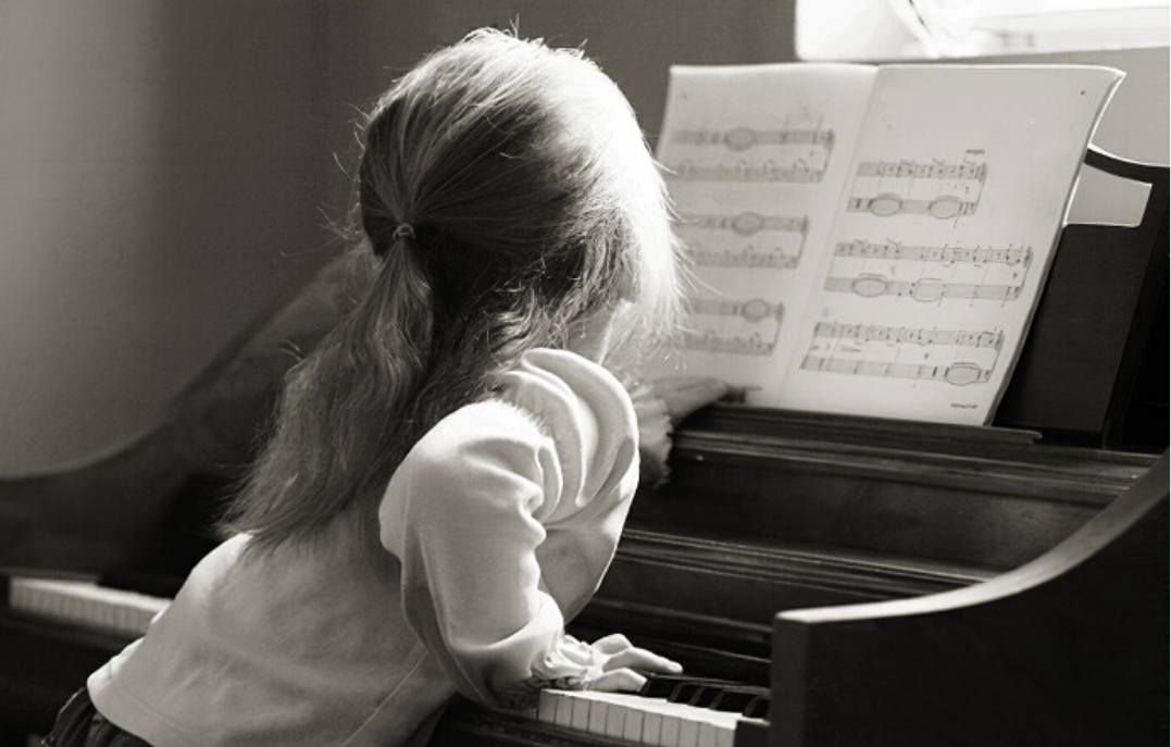 Первый ученик песня. Ребенок за роялем. Девочка за пианино. Девочка за фортепиано. Девочка за роялем.