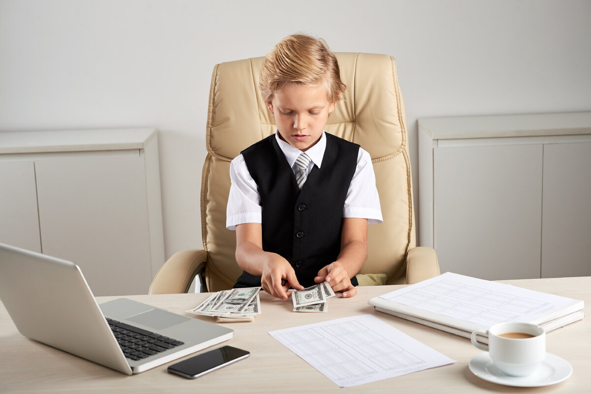 Авторство 👉 <a href="https://ru.freepik.com/free-photo/young-caucasian-boy-sitting-in-executive-chair-in-office-and-counting-dollars-on-desk_5839208.htm#query=%D0%A0%D0%B5%D0%B1%D0%B5%D0%BD%D0%BE%D0%BA%20%D0%B8%20%D0%B4%D0%B5%D0%BD%D1%8C%D0%B3%D0%B8&position=0&from_view=search">Изображение от pressfoto</a> на Freepik