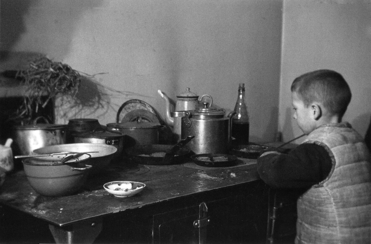 Школьник Миша Никитин у кухонной плиты в блокадном Ленинграде, январь 1942 года / waralbum.ru