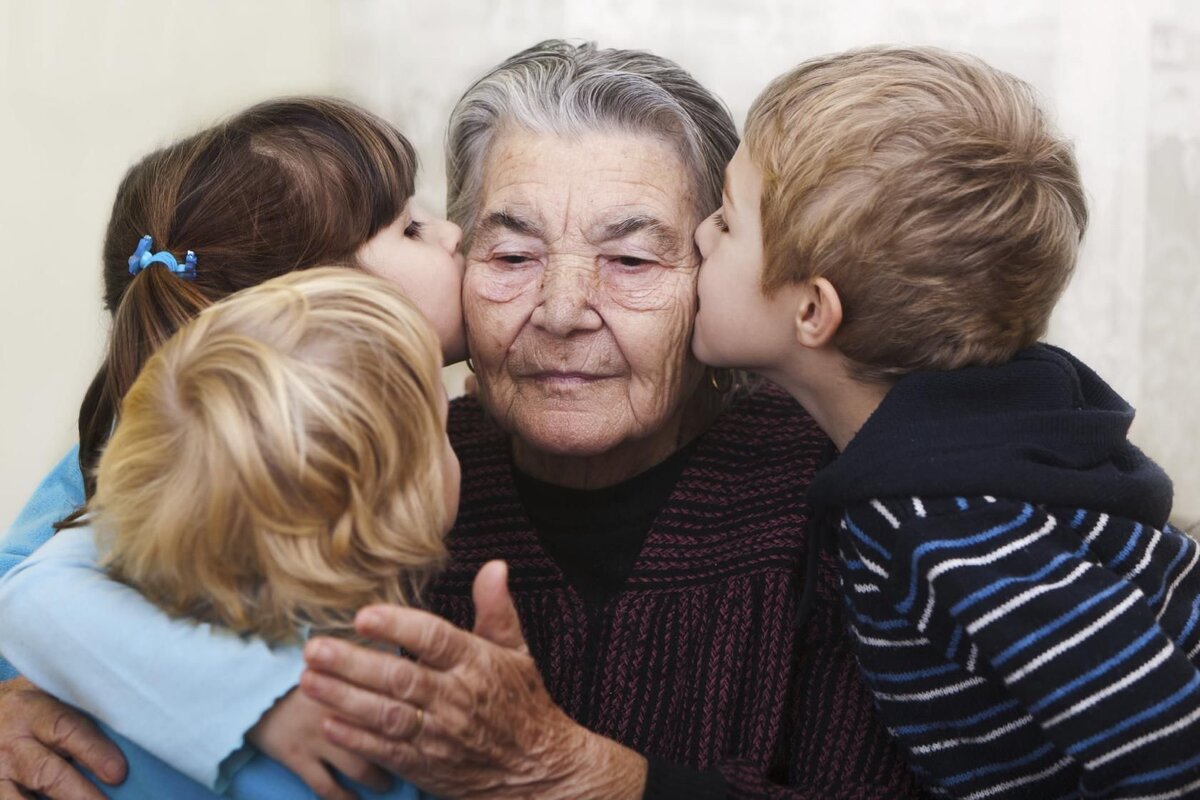 Пожилые и дети. Объятия пожилых. Бабушка обнимает внуков. Уважение к старости.