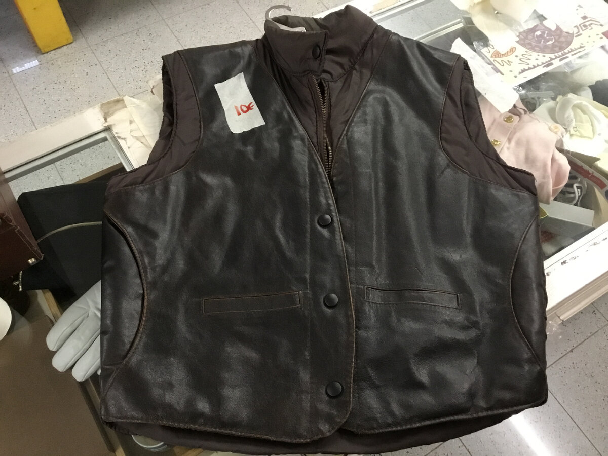 Интересная вещь. На фото не очень видно, но это от кожаного потрепанного жилета  отрезали переднюю часть и заднюю кокетку, нашили сверху на обыкновенный стеганый жилет и получилась очень красиво и добротно. Внутри застежка на молнию, а снаружи на кнопки. Оценили в 10 евро. Имеют же люди талант! 