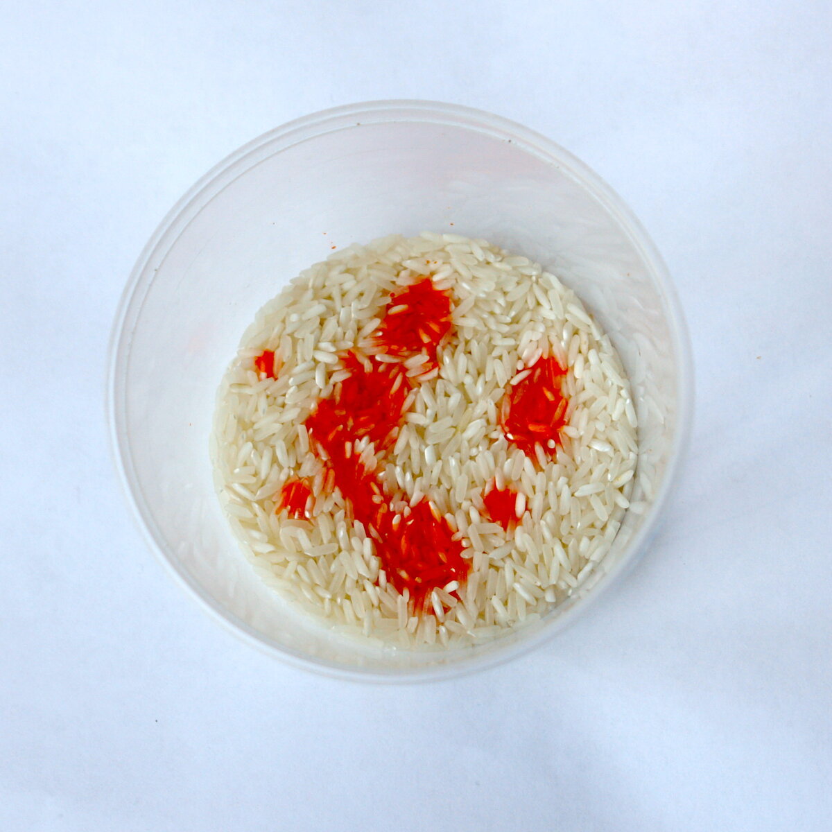 Горстка риса и упаковка жидкого красителя дадут необыкновенный пестрый рисунок. В пластиковую банку насыпьте сухой рис, вылейте краситель