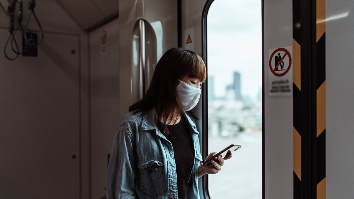 девушка со смартфоном у окна