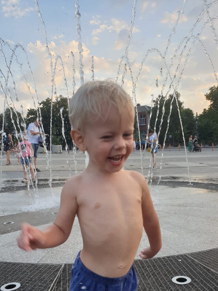 Малой бегает и веселится под струями фонтана