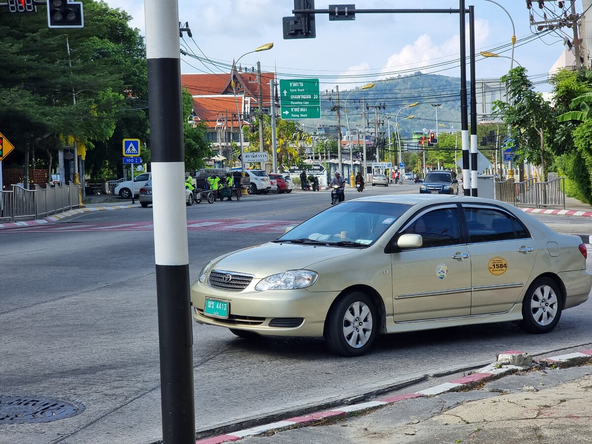 Типичное такси на острове: зеленые номерные знаки, желтая наклейка с номером для жалоб на водителя