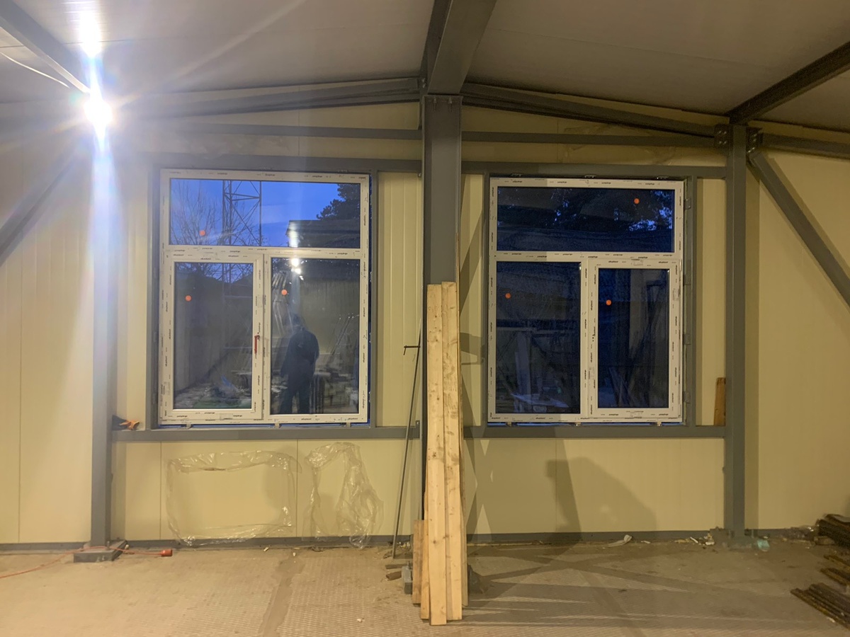 Так выглядит быстровозводимое здание из сэндвича после установки - железные стены и бетонное основание. Здесь на фото стены с диагональными подкосами.  Для жилых зданий есть проекты без них, чтобы полную площадь стены было удобно использовать.