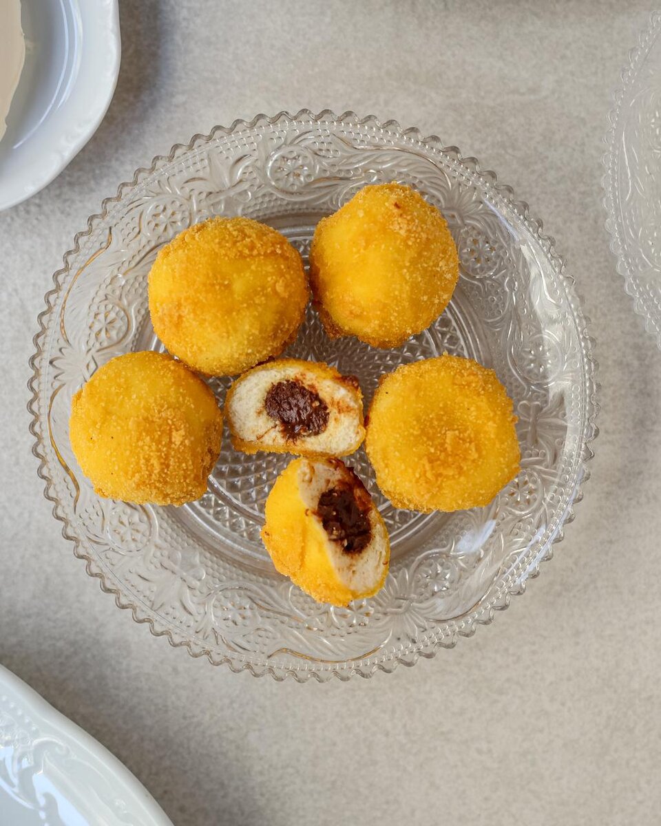 Привет, ребята.

Многие помнят, что я родом из Петербурга. А визитными карточками северной столицы являются медный всадник, кораблик на шпиле Адмиралтейства, разводные мосты, жареная корюшка, памятник чижику-пыжику и конечно же пышки!

Коренные петербуржцы с удовольствием раз в год едят пышки, вытирая жирные пальцы о салфетку, нарезанную из специальной, не впитывающей в себя ни капли жира, упаковочной бумаги. А потом сидят и меланхолично вздыхают глядя в белую стену пышечной на улице желябова.

И я, прожив в Москве мучительные семь лет, всем сердцем полюбил этот город, но скучать по пышкам не перестал. 

И сейчас, на дворе почти лето, захотелось пышек. 
Зачем себя ущемлять какими-то диетами, ведь я уже женат и моя ненаглядная меня завоевала. 
Решено было добавить в меню завтраков лучшего ресторана Москвы @ava.patriki этот шедевр для всех ностальгирующих по Питеру. 
Творожные пончики с начинкой из соленой карамели. 
В случае, если вы вдруг не в Москве, а вкусно позавтракать хотите, то вот вам рецепт:

Творог 9 % 350
Яйца 2шт
Манка 25
Сахар 90
Замесили , раскидали по 15 гр , завернули внутрь соленую карамель. 
Запанировали и пожарили во фритюре 


Товарищи, жду ваши вопросы и комментарии: «а где видеорецепт, коллега?»,  «понаехали, а Москва не резиновая», «в оригинальных пышках ни грамма творога, давно вы в Питере не бывали»
