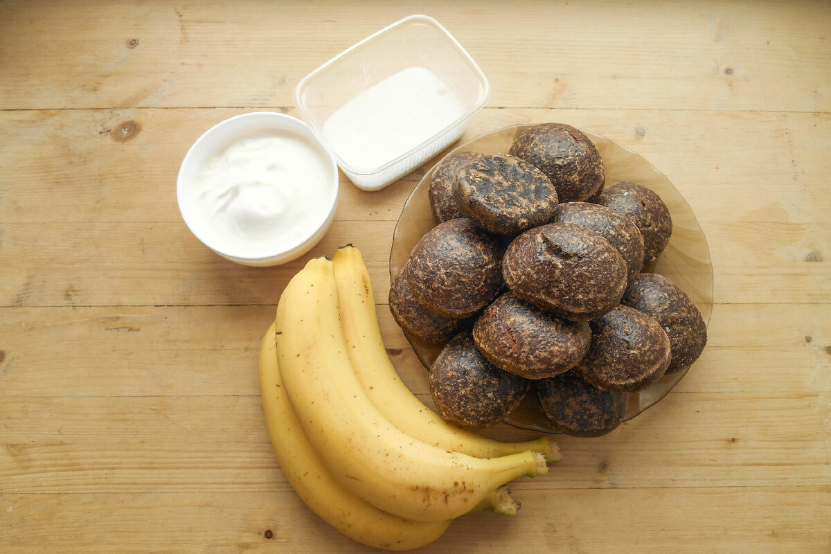 Для любителей сладкого предлагаю отличный вариант тортика без выпечки. У кого совсем нет времени возится с тестом, раскатывать коржи и выпекать бисквиты.
Для этого десерта достаточно взять пакет пряников, пару бананов и пачку сметаны.
И не отчаивайтесь, если пряники оказались не свежими и твёрдыми - этот торт стерпит всё!
Сметанный крем пропитает пряники до состояния нежной и тающей во рту консистенции.
Единственная трудность - это то, что придётся подождать несколько часов, пока тортик пропитается.
Ингредиенты:
шоколадные пряники - 500 грамм
сметана - 600 грамм
бананы - 3 штуки
сахар - 75 грамм
Шаг 1.
Для приготовления слоёного пряничного тортика возьмите бананы, пряники, сметану и сахар.
