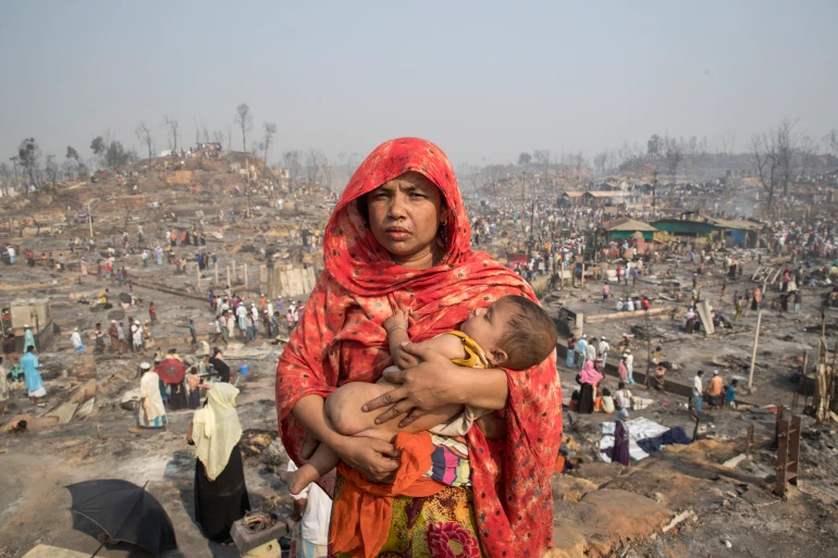 Мать рохинджа держит своего ребенка после того, как в их лагере в Бангладеш прокатился огромный пожар