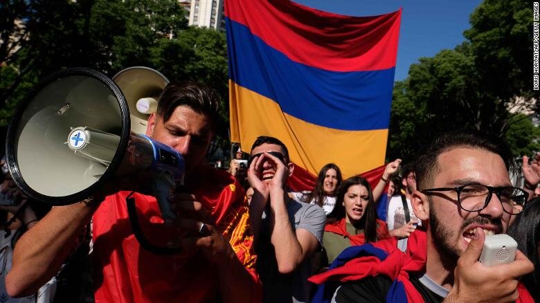 Люди маршируют с армянскими флагами в ознаменование 103-й годовщины массовых убийств армян османскими войсками 24 апреля 2018 года в Марселе, Франция.