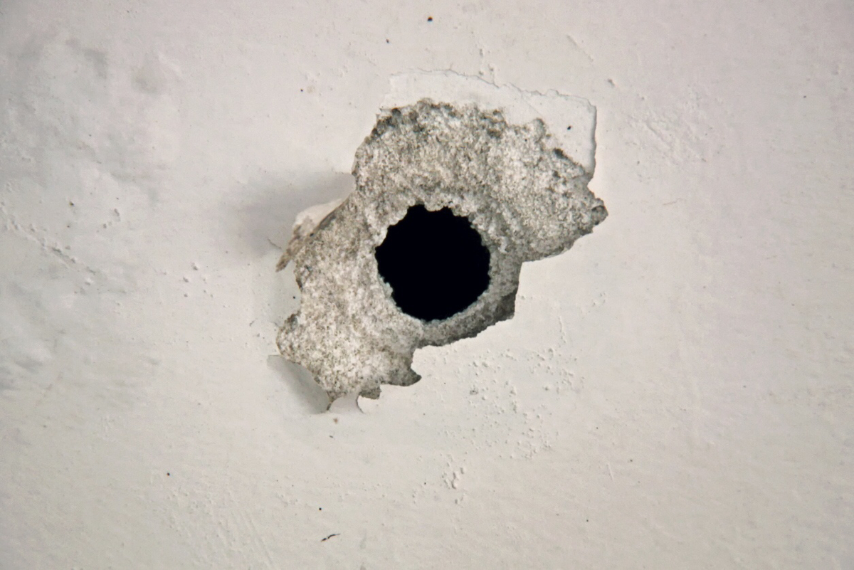 Трещина дыра. Стена с отверстиями от пуль. Дырка в стене. Дыра в бетонной стене. Пулевое отверстие в бетоне.