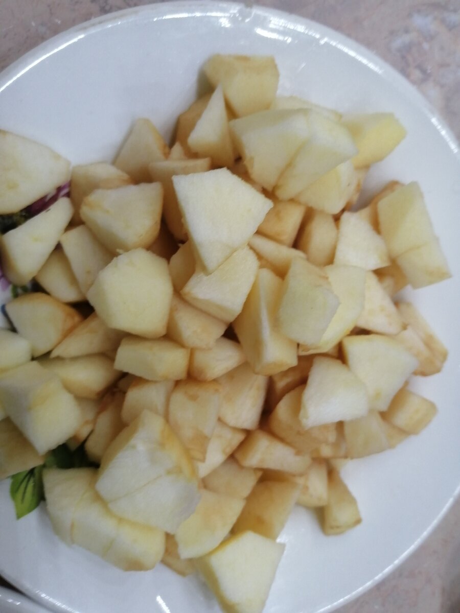 На фотографии изображено очищенное и порезанное на кубики яблоко.