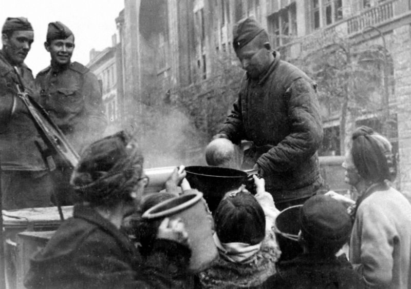 Русский солдат выдаёт еду гражданам Германии