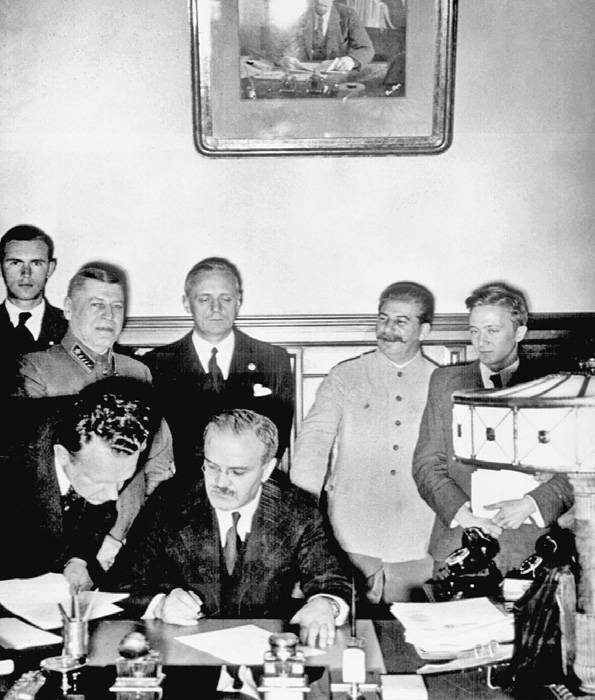 Подписание Договора о ненападении (Молотов подписывает договор, за ним Риббентроп, справа Сталин). 23 августа 1939 г.