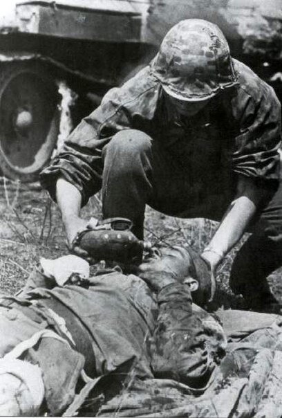Солдат SS оказывает помощь бойцу Красной Армии.