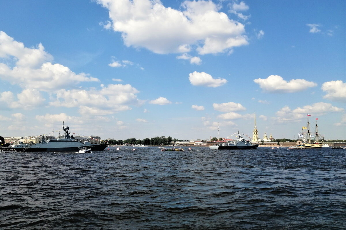 За Дворцовым мостом на рейде малый ракетный корабль "Серпухов" и малый ракетный корабль "Мытищи". Возглавляет парадную линию кораблей линейный корабль "Полтава", реконструкция корабля, созданного Петром I в 1712 году.