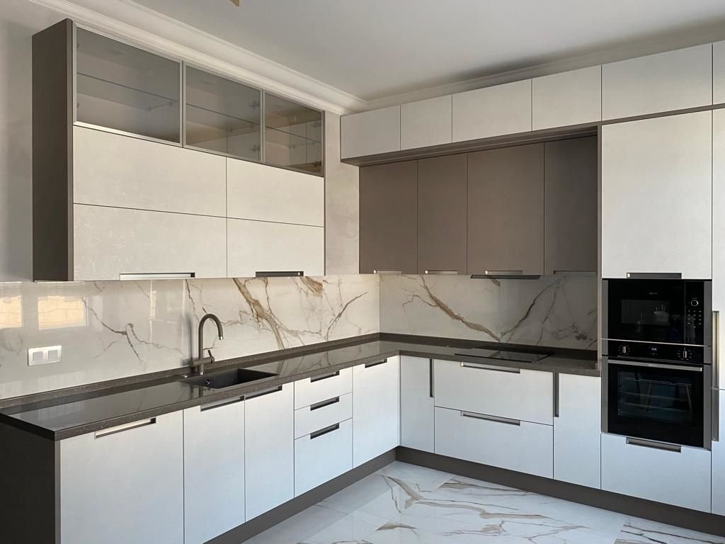 Кухня «Spark» особенно эффектно смотрится с природными текстурами. Так в проекте «Марии» выразительная напольная плитка подчёркивает натуралистичные текстуры гарнитура. А ещё – удачно скрадывает мелкие пятна